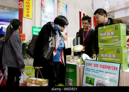 Visitatori acquistare verdura biologica in corrispondenza di un supporto durante il IX Wuhan Cina Agricoltura Expo nella città di Wuhan, Cina centrale della provincia di Hubei, 4 novembre 2012. Foto Stock