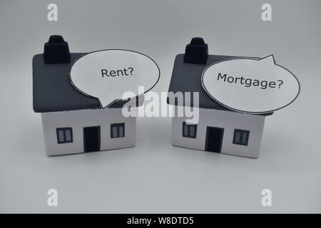 Due case con il discorso di scatole, uno dice 'affitto?", l'altra dice 'Buy?". Si tratta di un dilemma di fronte al giovane e alcune persone anziane. Foto Stock