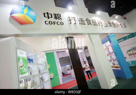 --FILE--un dipendente cinese è visto presso lo stand di COFCO (China National i cereali, gli oli e i prodotti alimentari Corporation) durante una mostra a Pechino, Ch Foto Stock