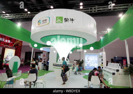 --FILE -- la gente visita lo stand della COFCO (China National i cereali, gli oli e i prodotti alimentari Corporation) e gruppo Mengniu durante la Cina bambini e Donn Foto Stock