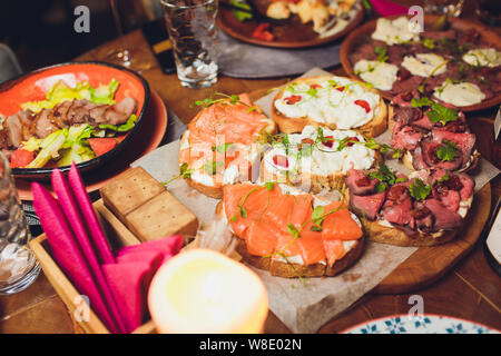 Antipasti tabella con antipasti italiani spuntini e il vino in bicchieri. Spaghetti o autentici tradizionali tapas spagnoli, varietà di formaggio su scheda Foto Stock