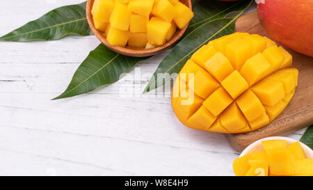 Tritato fresco mango su un vassoio e luminose in legno rustico sfondo. Tropical frutta estiva design concept, close up, macro, copia dello spazio. Foto Stock