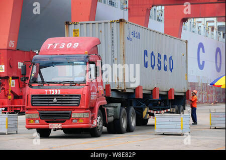 --FILE -- un carrello è caricato con un contenitore di Cosco sbarcato da una nave portacontainer su una banchina del porto di Qingdao nella città di Qingdao, est della Cina di Shan Foto Stock