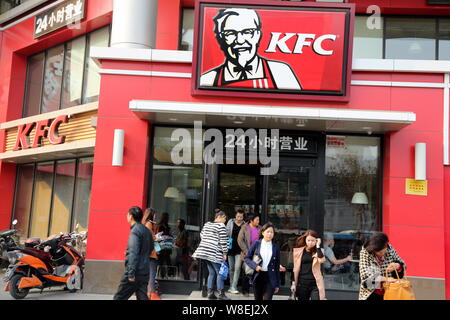 --FILE--i clienti cinesi entrare o uscire da un un fast food ristorante di KFC in Zhengzhou city, centrale cinese della provincia di Henan, 26 ottobre 2013. Per Yum Bra Foto Stock