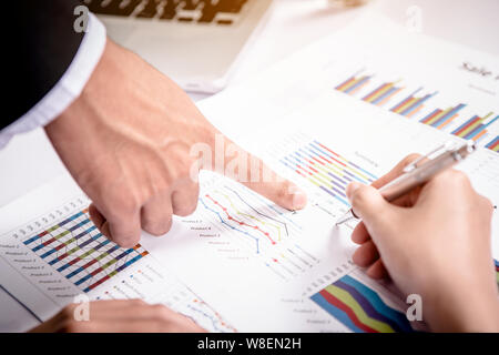 Due business discutendo il regime e maniglie di puntamento sul grafico Foto Stock
