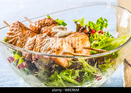 Salmone alla griglia spiedini con insalata estiva salat pomehranate semi Olio d'oliva e condimento. Pesce sano cibo con frutta e verdura Foto Stock