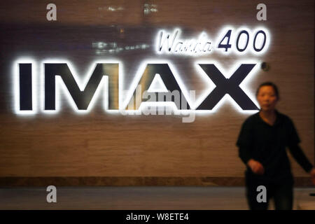 --FILE--una donna cinese cammina davanti a un cartello di Wanda dotato di Cinema IMAX in Cina a Shanghai, 28 marzo 2011. IMAX Corp, IMAX Cina Holdin Foto Stock