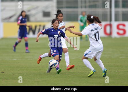 I giocatori di Uzbekistan sfida Yuka Anzai del Giappone in una partita di calcio durante il 2015 AFC U-19 campionato delle donne nella città di Nanjing, a est della Cina di Jian Foto Stock