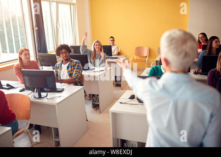 Sorridendo gli studenti domande mentre frequentano lezioni in campus Foto Stock