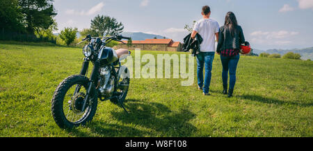 Giovane camminando sul campo tenendo le mani e moto Foto Stock