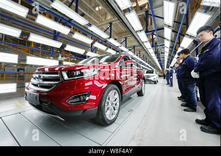 Lavoratori cinesi guardare SUV Ford passando attraverso la linea di montaggio presso l'impianto automatico di Changan Ford in Hangzhou, est della Cina di provincia dello Zhejiang, Foto Stock