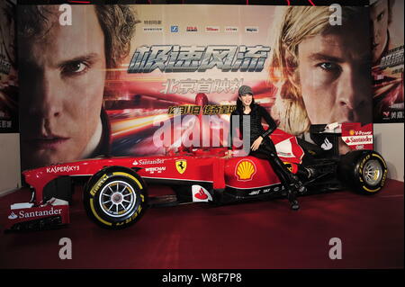Attrice canadese Christy Chung pone appoggiata su una Ferrari Formula One race car durante una Premiere per il film 'rush' a Pechino in Cina, 10 Dicembre 2 Foto Stock
