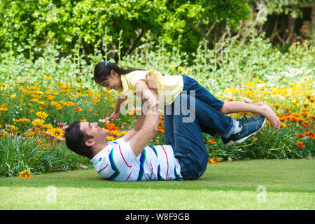 Man playing with his daughter in a park Stock Photo