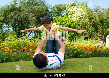 Man playing with his daughter in a park Stock Photo