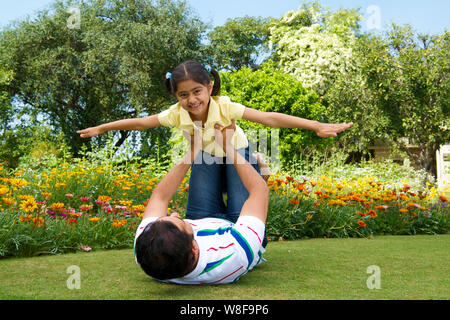 Man playing with his daughter in a park Stock Photo