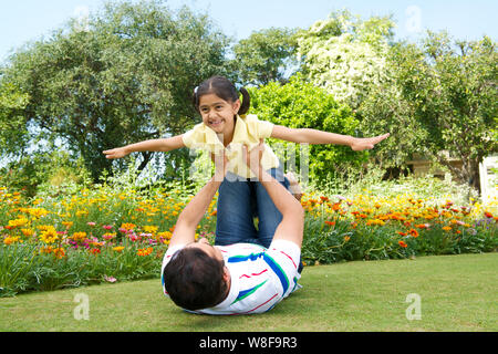 Man playing with his daughter in a park Stock Photo