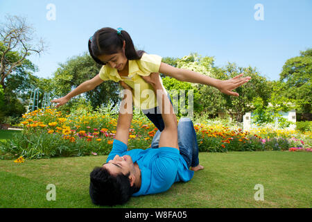 Man playing with his daughter in a park Stock Photo