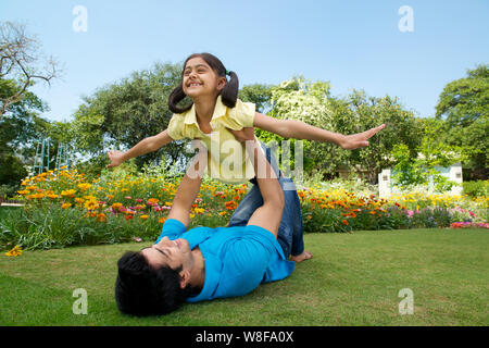 Man playing with his daughter in a park Stock Photo