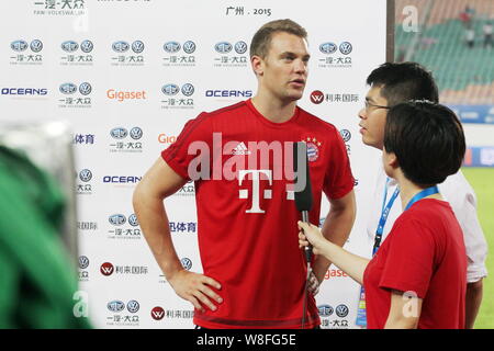 Il portiere Manuel Neuer del Bayern Monaco di Baviera, a sinistra viene intervistato dopo che il suo team è stato sconfitto da Guangzhou Evergrande durante un amichevole partita di calcio in G Foto Stock