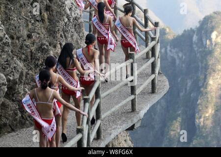 Bikini-modelli di vestiti a piedi in tacchi alti su una passerella sul precipizio di una montagna durante un concorso di bellezza nella contea di Luanchuan, centrale della Cina di Henan Foto Stock