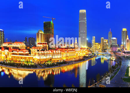 Vista notturna di edifici ad alta lungo la riva del fiume Hai o Fiume Haihe di Tianjin, Cina, 21 settembre 2014. Foto Stock