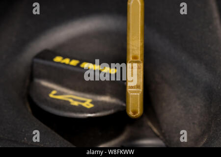 Primo piano della macchina di riempimento olio motore e tappo giallo di gestire l'astina di livello olio del motore Foto Stock