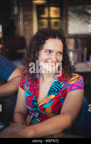 Una foto di stile di vita di una giovane bruna caucasica che socializza in un ristorante. Foto Stock