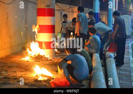 --FILE--Cinesi locali residenti masterizzare joss carta moneta a piangere i loro parenti su una banchina in Ghost Festival nella città di Hefei, Cina orientale¯s Anhui p Foto Stock