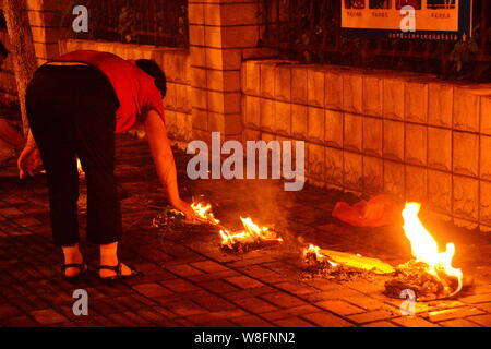 --FILE -- Un locale residente cinese brucia joss carta moneta a piangere i suoi parenti su una banchina in Ghost Festival nella città di Hefei, Cina orientale¯s Anhui p Foto Stock