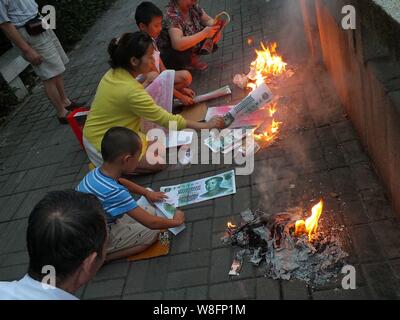 --FILE--Cinesi locali residenti masterizzare joss carta moneta a piangere i loro parenti lungo un argine a Yichang city, centrale cinese della provincia di Hubei, 8 Ma Foto Stock