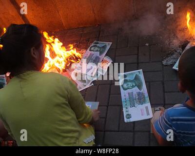 --FILE--Cinesi locali residenti masterizzare joss carta moneta a piangere i loro parenti lungo un argine a Yichang city, centrale cinese della provincia di Hubei, 8 Ma Foto Stock