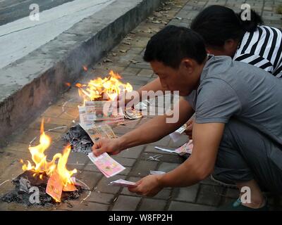 --FILE--Cinesi locali residenti masterizzare joss carta moneta a piangere i loro parenti lungo un argine a Yichang city, centrale cinese della provincia di Hubei, 8 Ma Foto Stock