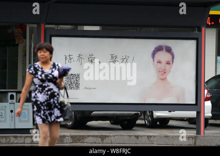 Una passeggiate a piedi passato un annuncio con una fotografia di una donna che indossa il suo abito da sposa e i caratteri cinesi, che significa 'Qiaorong Chen, sposarsi m Foto Stock