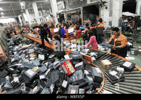 --FILE--lavoratori cinesi ordinamento pacchi, la maggior parte dei quali sono da shopping online, presso un centro di distribuzione di STO Express o Shentong Express di Wenzhou c Foto Stock