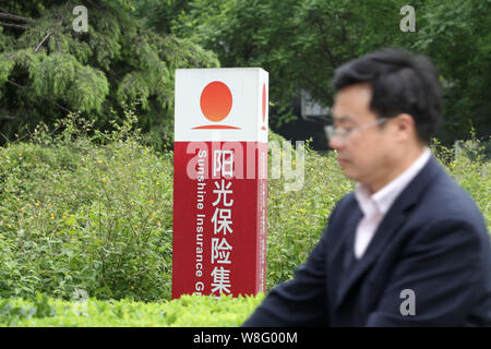 --FILE--A passeggiate a piedi passato un cartello di sole gruppo assicurativo a Pechino, in Cina, il 10 maggio 2014. New York¯s Baccarat Hotel dispone ancora di verificare i Foto Stock