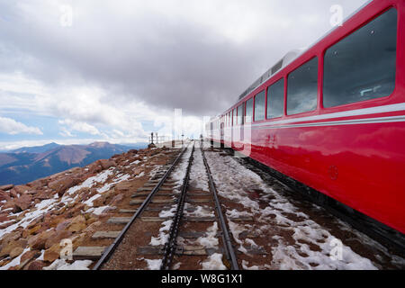 Alta montagna treno corre su un paesaggio innevato. Foto Stock