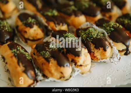 Dolce tradizionale francese eclair o profiterole dessert sulla tavola. Foto Stock