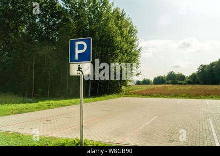 Lo spazio libero di parcheggio per disabili spot con verdi alberi intorno Foto Stock