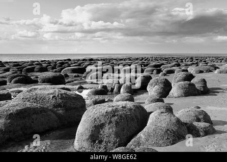 Carattere distintivo di grandi massi in formazione attraverso la spiaggia sabbiosa di Hunstanton, Norfolk Foto Stock