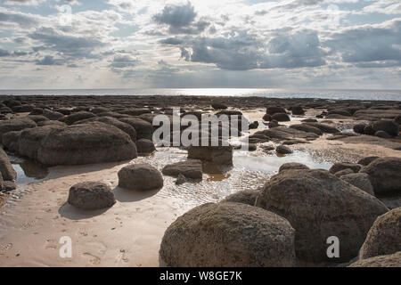 Carattere distintivo di grandi massi in formazione attraverso la spiaggia sabbiosa di Hunstanton, Norfolk Foto Stock