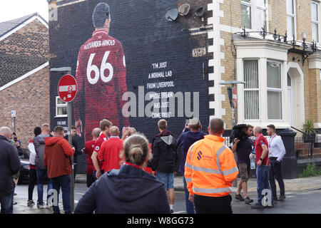 Liverpool, Regno Unito. Il 9 agosto 2019. Tifosi del Liverpool ammirare il nuovo Trento Alexander Arnold murale di Sybil Road vicino al suolo prima della prima partita in casa della stagione 2019-2020 contro Norwich ad Anfield. Dipinto dal francese Graffiti artist Akse, e disposti da Liverpool FC ventola il podcast Anfield Wrap. Il murale è dedicato ai fan Foodbanks di supporto, un'iniziativa locale fondata da spirito di Shankly e Everton sostenitori fiducia per la lotta contro la povertà alimentare nel nord di Liverpool. Credit:Ken Biggs/Alamy Live News. Foto Stock
