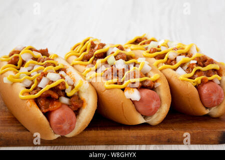 In casa Coney Island hot dog su un rustico di legno su un bianco sullo sfondo di legno, vista laterale. Close-up. Foto Stock