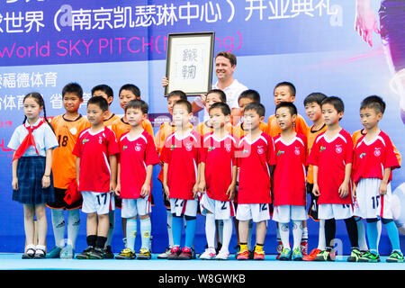 Pensionato inglese football star Michael Owen, indietro, pone con bambini alla cerimonia di apertura per la SoccerWorld Estate festa del calcio in Nanjing Foto Stock