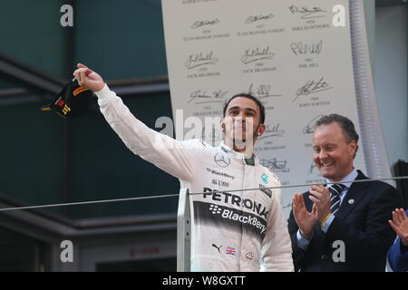 In Gran Bretagna da Lewis Hamilton di Mercedes, anteriore, saluta tifosi durante la cerimonia di premiazione del 2015 Formula 1 Gran Premio di Cina a Shanghai la Internatio Foto Stock