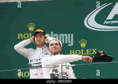 In Gran Bretagna da Lewis Hamilton di Mercedes, anteriore, saluta i fan davanti al suo compagno di squadra in Germania a Nico Rosberg durante la cerimonia di premiazione del 2015 Formula Foto Stock