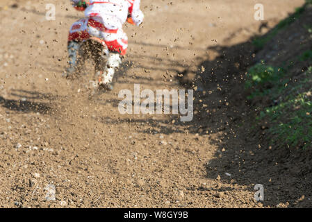 Atleta non riconosciuto in sella a una moto sportiva fangoso e ruota su una pista di motocross racing event Foto Stock