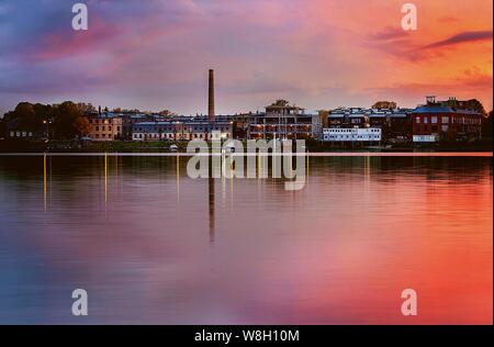Bellissimo scatto di una città sul lago sotto un cielo rosa Foto Stock