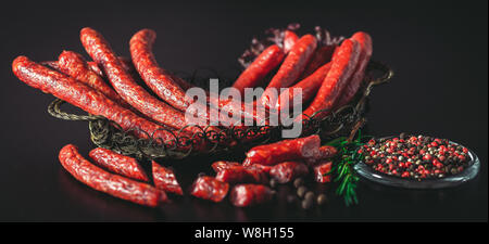 Caccia salsicce salsicce su uno sfondo scuro. Foto Stock