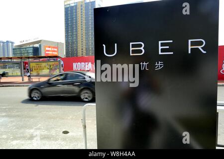 --FILE -- un auto corre passato un cartello del taxi-salutando app Uber nella città di Guangzhou, Cina del sud della provincia di Guangdong, 23 settembre 2015. Uber è l Foto Stock