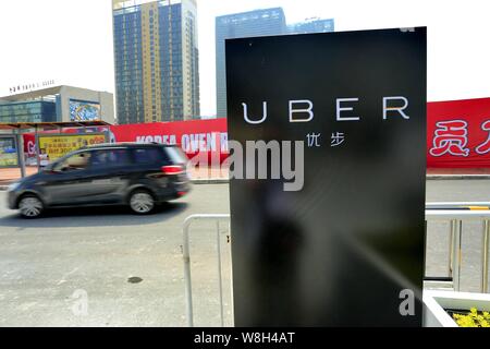 --FILE -- un auto corre passato un cartello del taxi-salutando app Uber nella città di Guangzhou, Cina del sud della provincia di Guangdong, 23 settembre 2015. Uber è l Foto Stock